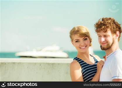 Travel tourism and people concept. Young tourist couple on vacation standing in front of boats sea water