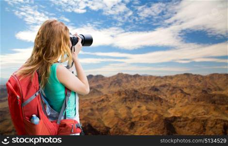 travel, tourism and photography concept - happy young woman with backpack and camera photographing over grand canyon national park hills background. woman with backpack and camera at grand canyon. woman with backpack and camera at grand canyon