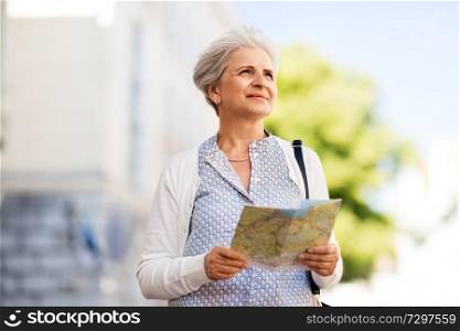 travel, tourism and retirement concept - senior woman or tourist with map on city street. senior woman or tourist with map on city street