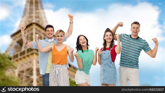 travel, tourism and summer holidays concept - group of happy smiling friends making fist pump gesture over eiffel tower background. friends making fist pump gesture over eiffel tower