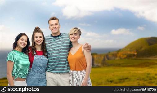 travel, tourism and summer holidays concept - group of happy smiling friends hugging over big sur coast of california background. happy friends hugging over white background