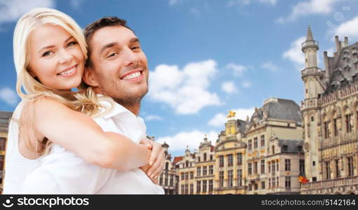 travel, tourism and summer holidays concept - happy couple over grand place in brussels background. happy couple over grand place in brussels