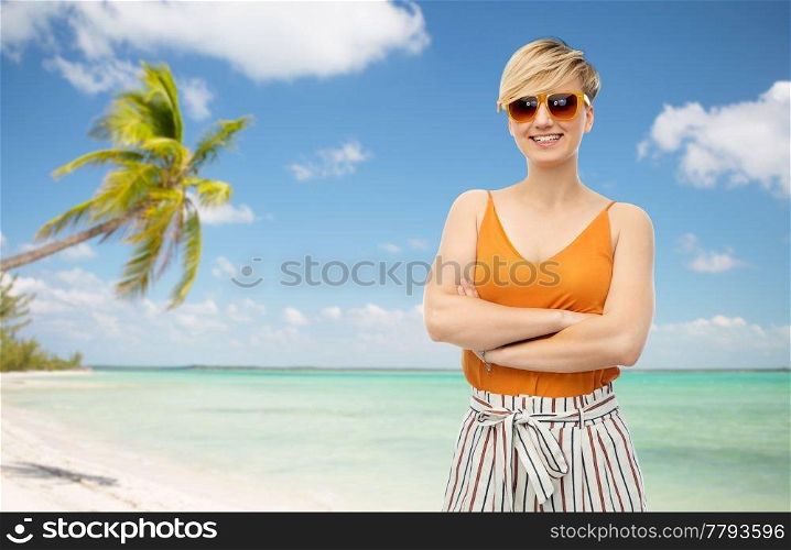 travel, tourism and summer holidays concept - happy smiling young woman in sunglasses over exotic tropical beach with palm trees background. happy smiling young woman over white background