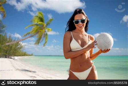 travel, tourism and summer holidays concept - happy smiling young woman in bikini swimsuit posing with volleyball over tropical beach background in french polynesia. woman in bikini posing with volleyball on beach
