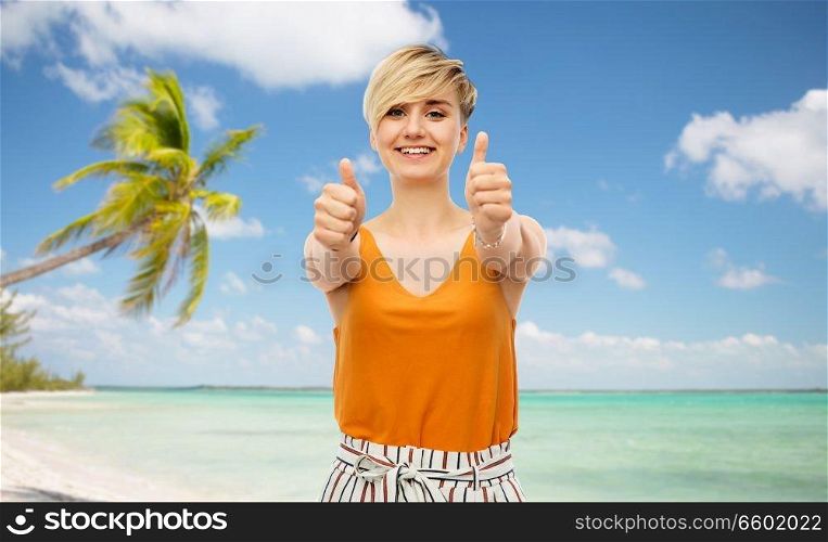 travel, tourism and summer holidays concept - happy smiling young woman showing thumbs up over exotic tropical beach with palm trees background. happy smiling young woman showing thumbs up