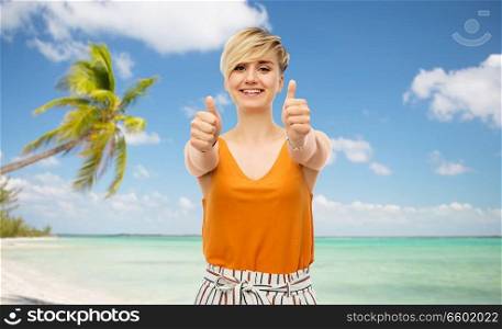 travel, tourism and summer holidays concept - happy smiling young woman showing thumbs up over exotic tropical beach with palm trees background. happy smiling young woman showing thumbs up