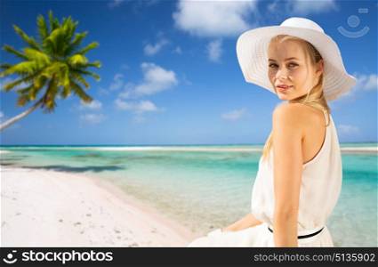 travel, tourism and summer vacation concept - beautiful woman in hat enjoying sun over tropical beach background in french polynesia. beautiful woman enjoying summer over beach. beautiful woman enjoying summer over beach