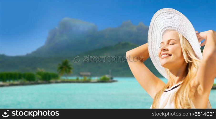 travel, tourism and summer vacation concept - beautiful woman in hat enjoying sun over exotic bora bora beach background. beautiful woman enjoying summer bora bora beach. beautiful woman enjoying summer bora bora beach