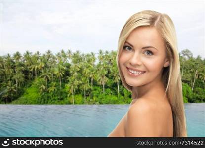 travel, tourism and summer vacation concept - beautiful woman over infinity edge pool and palms in sri lanka background. happy woman over infinity edge pool in sri lanka