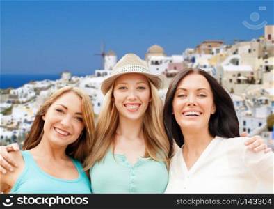 travel, tourism and summer vacation concept - group of happy smiling women or friends over oia town on santorini island background. happy women over santorini island background