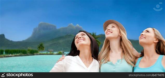 travel, tourism and summer vacation concept - group of happy smiling women or friends over bora bora background. happy women over bora bora background. happy women over bora bora background