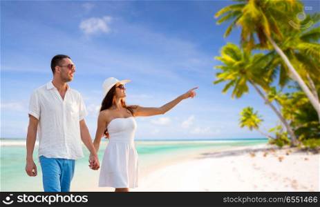travel, tourism and summer vacation concept - happy couple on vacation wearing sunglasses and walking holding hands over tropical beach background in french polynesia. happy couple on vacation over tropical beach. happy couple on vacation over tropical beach