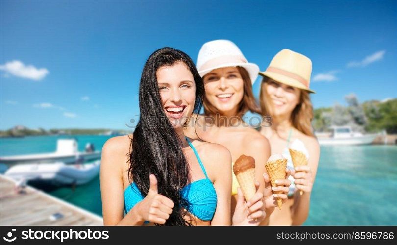 travel, tourism and summer vacation concept - happy women in bikinis with ice cream over wooden pier and boat on tropical beach background in french polynesia. happy women in bikinis with ice cream on beach