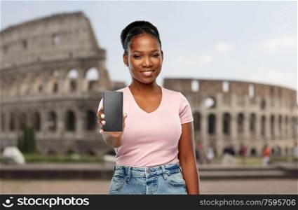 travel, tourism and technology concept - happy african american woman using smartphone over coliseum background. african american woman with smartphone at coliseum