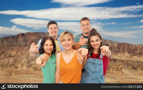 travel, tourism and vacation concept - group of happy smiling friends pointing at you over grand canyon national park background. friends pointing at you over grand canyon