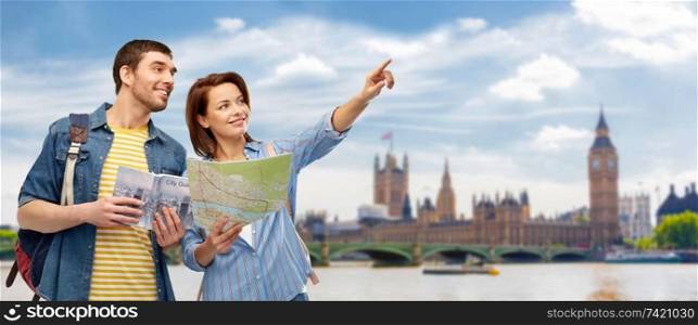 travel, tourism and vacation concept - happy couple of tourists with city guide, map and backpacks over london city background. happy couple of tourists with city guide and map