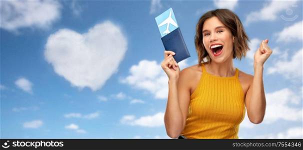 travel, tourism and vacation concept - happy laughing young woman in mustard yellow top with air ticket and passport over blue sky and clouds background. happy young woman with air ticket and passport