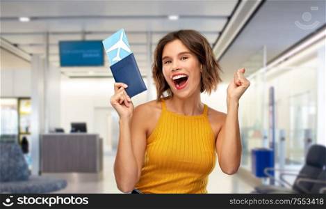 travel, tourism and vacation concept - happy laughing young woman in yellow top with air ticket and passport over airport lounge background. happy young woman with air ticket and passport