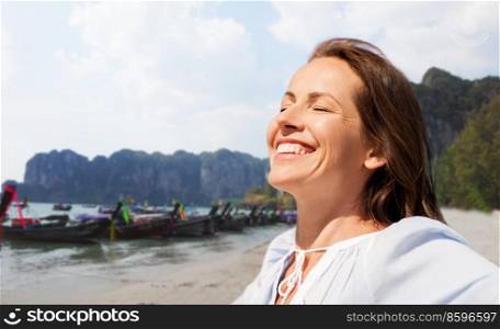 travel, tourism and vacation concept - happy smiling woman enjoying sun over tropical beach background in french polynesia. happy smiling woman enjoying sun on tropical beach