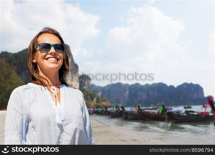 travel, tourism and vacation concept - happy smiling woman in sunglasses over tropical beach background in french polynesia. smiling woman in sunglasses on tropical beach