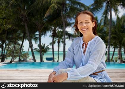 travel, tourism and vacation concept - happy smiling woman over swimming pool on tropical beach background in french polynesia. happy smiling woman on tropical beach