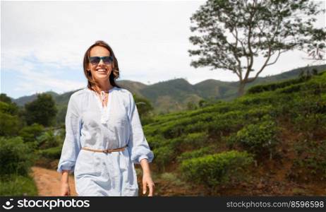 travel, tourism and vacation concept - happy smiling woman walking over sri lanka natural background. happy smiling woman walking at sri lanka