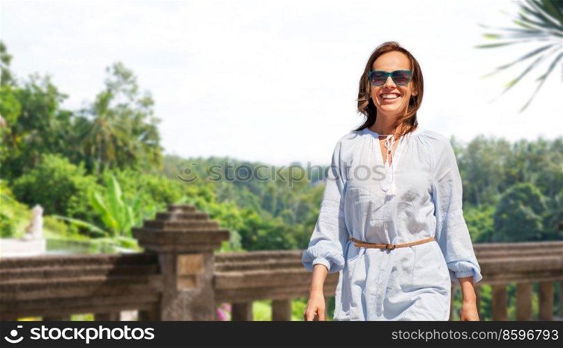 travel, tourism and vacation concept - happy smiling woman walking over terrace in thailand on background. happy smiling woman walking on terrace in thailand