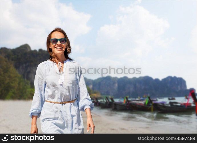 travel, tourism and vacation concept - happy smiling woman walking over tropical beach background in french polynesia. happy smiling woman walking along tropical beach