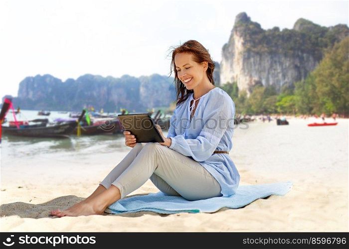 travel, tourism and vacation concept - happy smiling woman with tablet pc computer over tropical beach background in french polynesia. happy smiling woman with tablet pc on summer beach