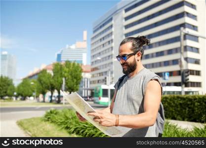 travel, tourism, backpacking and people concept - man traveling with backpack and map in city searching location