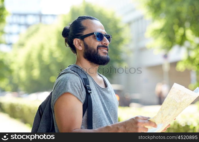 travel, tourism, backpacking and people concept - man traveling with backpack and map in city searching location