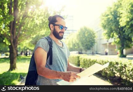 travel, tourism, backpacking and people concept - man traveling with backpack and map in city searching location. man traveling with backpack and map in city. man traveling with backpack and map in city