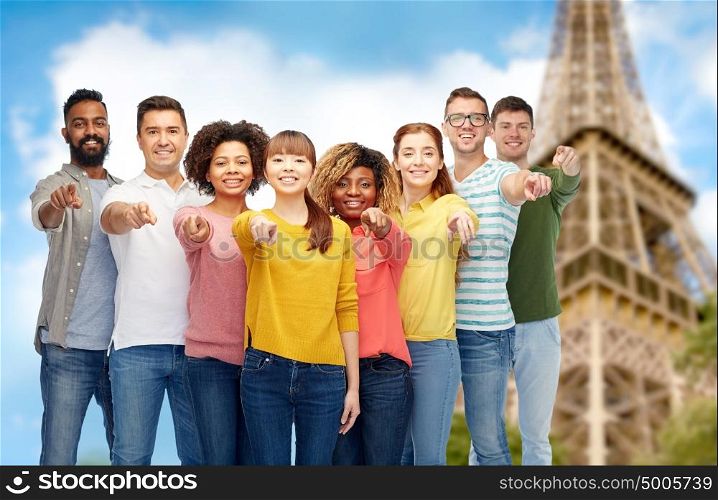 travel, tourism, diversity and people concept - international group of happy smiling men and women pointing finger on you over eiffel tower background. international group of people pointing on you