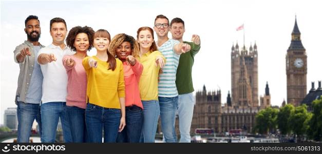 travel, tourism, diversity, and people concept - international group of happy smiling men and women pointing finger on you over london city background. international group of people pointing on you