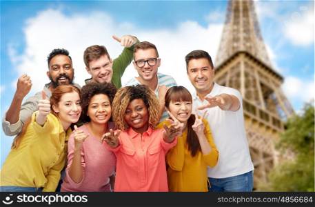 travel, tourism, diversity, ethnicity and people concept - international group of happy smiling men and women showing thumbs up and peace over eiffel tower background