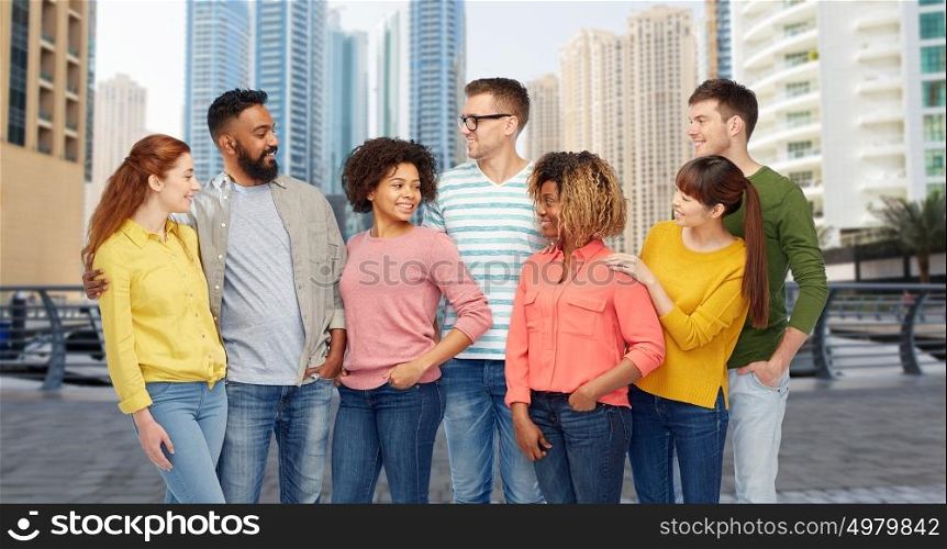 travel, tourism, diversity, ethnicity and people concept - international group of happy smiling men and women over dubai city street background. international group of people talking in city
