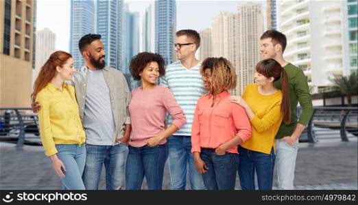 travel, tourism, diversity, ethnicity and people concept - international group of happy smiling men and women over dubai city street background. international group of people talking in city
