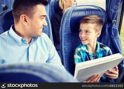 travel, tourism, family, technology and people concept - happy father and son with tablet pc computer sitting in travel bus. happy family with tablet pc sitting in travel bus