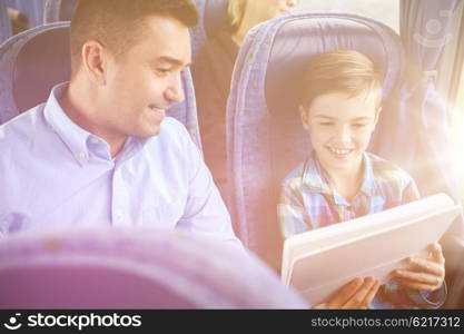 travel, tourism, family, technology and people concept - happy father and son with tablet pc computer sitting in travel bus