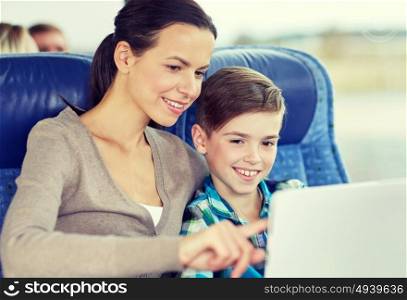 travel, tourism, family, technology and people concept - happy mother and son with tablet pc computer sitting in travel bus or train. happy family with tablet pc sitting in travel bus