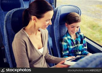 travel, tourism, family, technology and people concept - happy mother and son with tablet pc computer sitting in travel bus. happy family with tablet pc sitting in travel bus