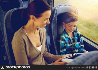 travel, tourism, family, technology and people concept - happy mother and son with tablet pc computer sitting in travel bus