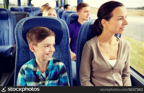 travel, tourism, family, technology and people concept - happy mother and son riding in travel bus. happy family riding in travel bus