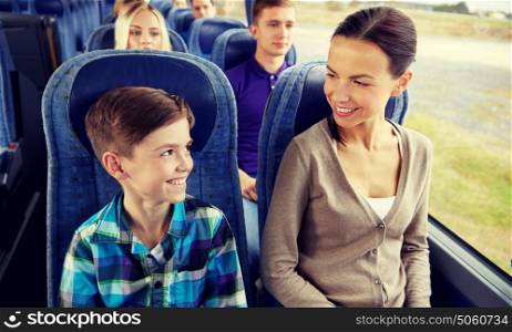 travel, tourism, family, technology and people concept - happy mother and son riding in travel bus. happy family riding in travel bus
