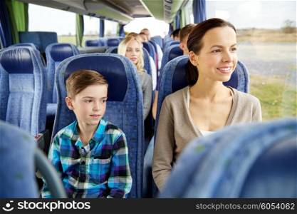 travel, tourism, family, technology and people concept - happy mother and son riding in travel bus