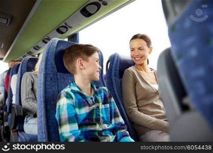 travel, tourism, family, technology and people concept - happy mother and son riding in travel bus