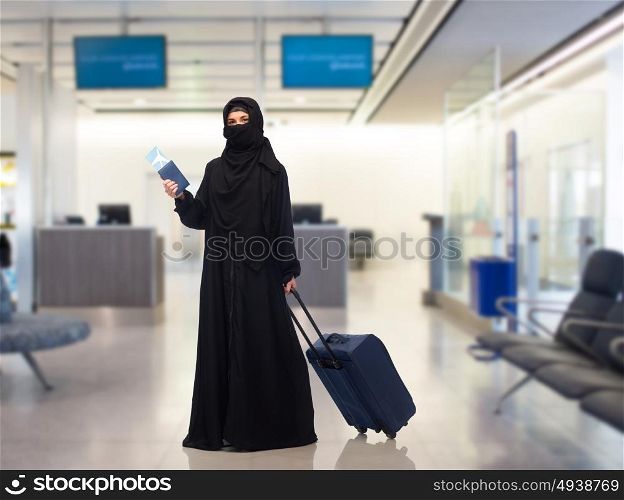 travel, tourism, flight and people concept - muslim woman in hijab with airplane ticket, passport and carry-on bag over airport waiting room background. muslim woman with ticket, passport and travel bag
