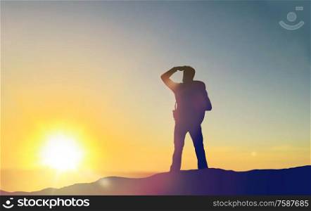 travel, tourism, hike and people concept - traveller with backpack standing on edge of hill and looking far away over sunrise background. traveller looking far away over sunrise