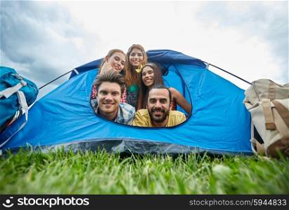 travel, tourism, hike, equipment and people concept - group of happy friends with backpacks in tent at camping