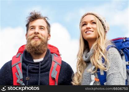 travel, tourism, hiking and people concept - couple of travelers with backpacks outdoors. couple of travelers with backpacks hiking